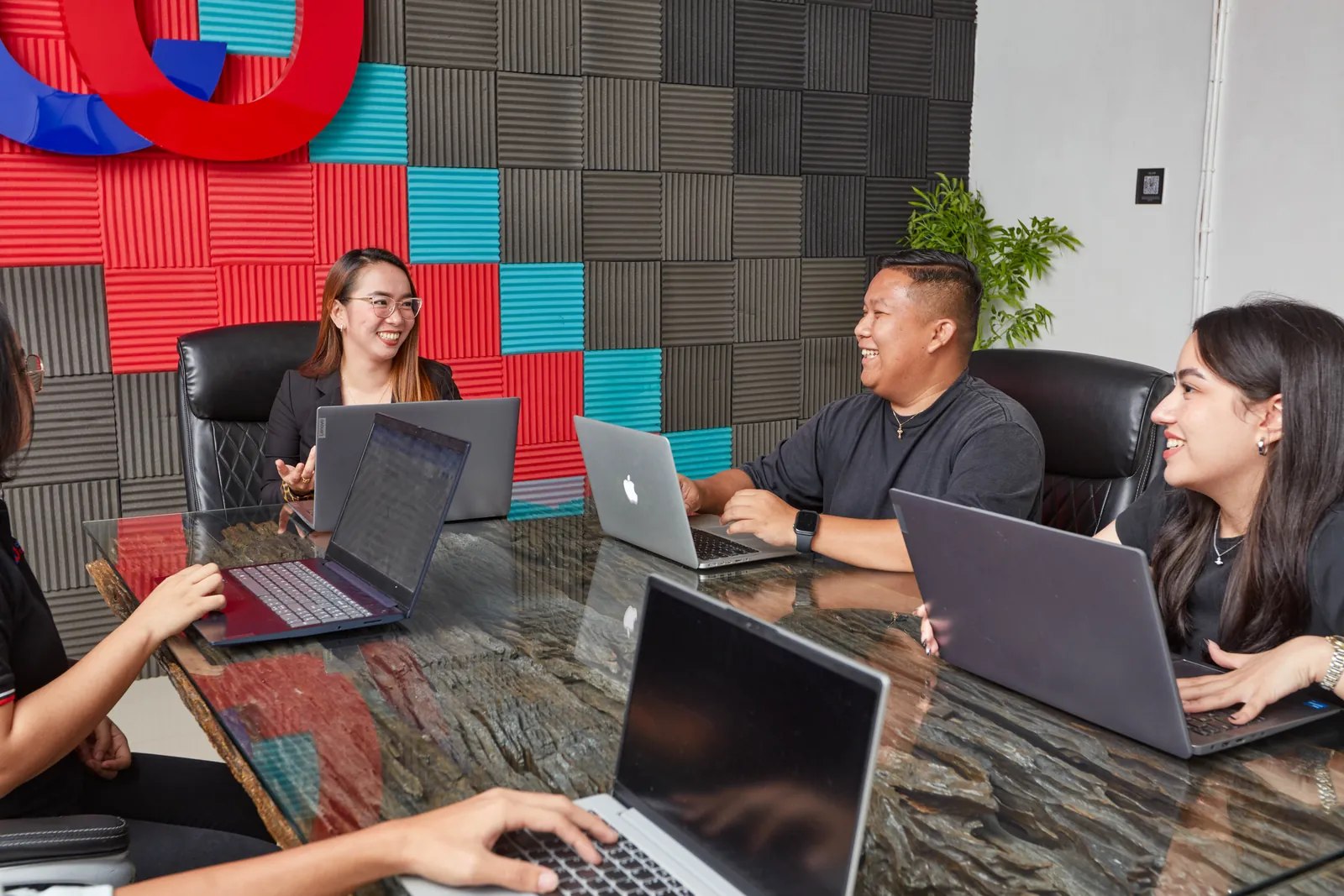 Colleagues meeting with laptops at our Clark, Philippines office