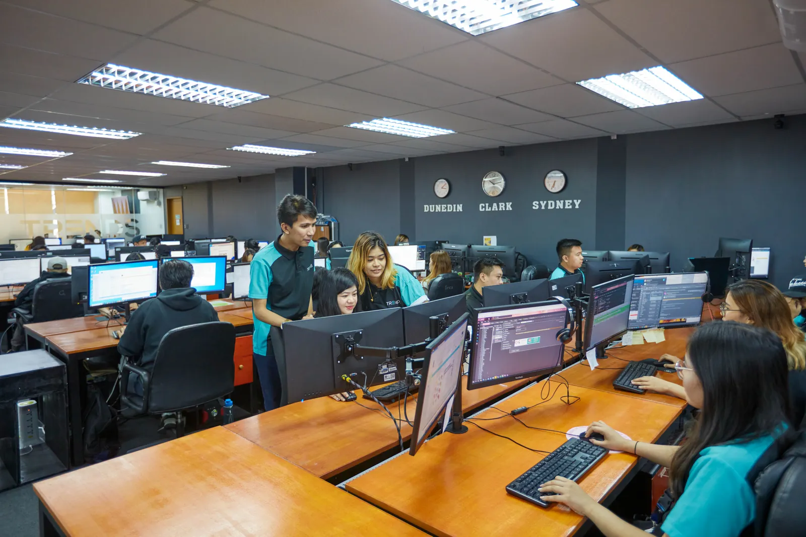 Colleagues coordinating work beside computers in our Philippines office, supporting organized claims processing workflows