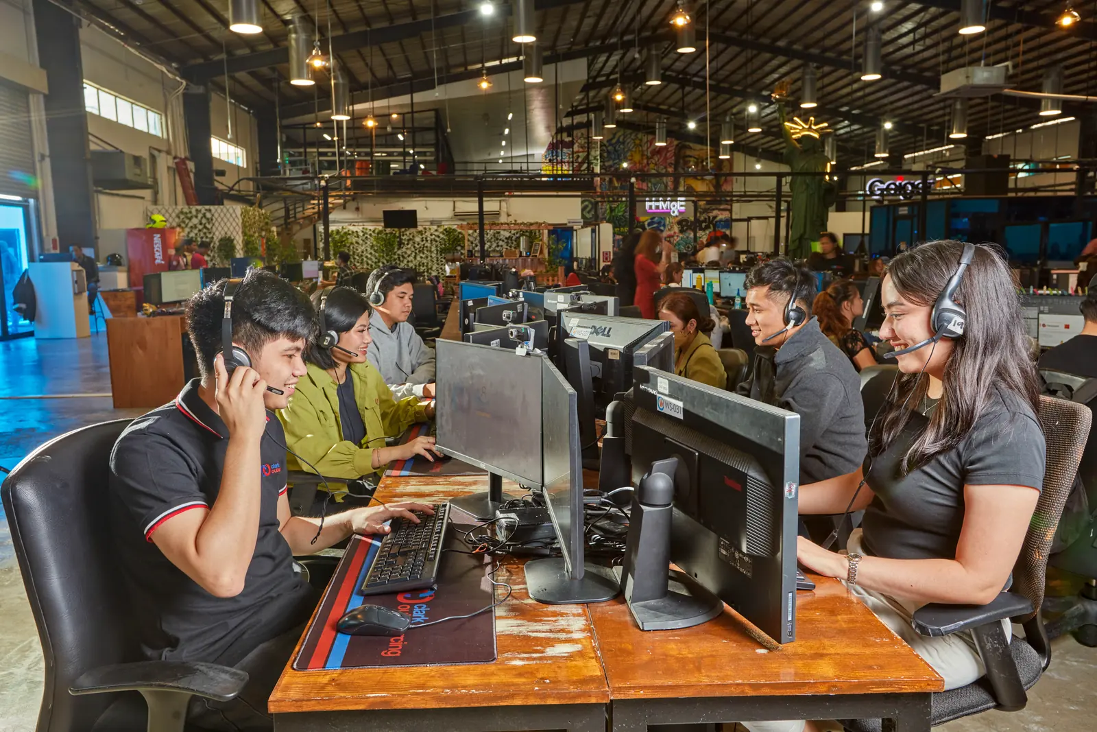 Colleagues using headsets and computers in our Clark, Philippines outsourcing office